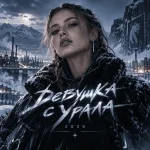 Девушка в тёмной куртке с меховым капюшоном на фоне снежного промышленного пейзажа и гор